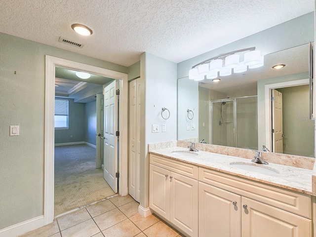 bathroom featuring tile patterned floors, a shower with door, a textured ceiling, and vanity