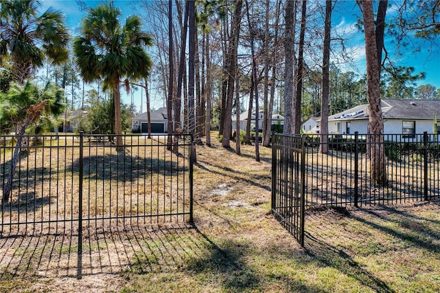 view of gate with a lawn