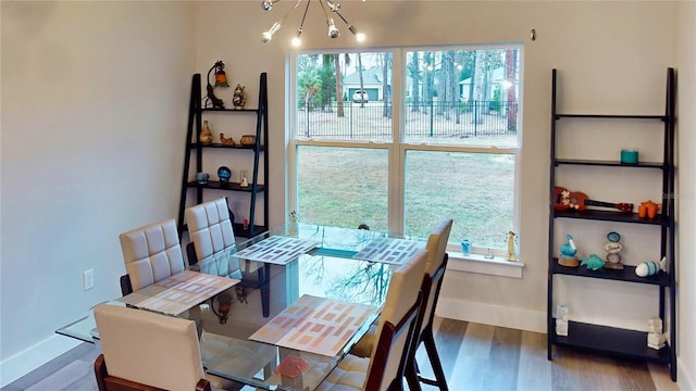 dining space featuring an inviting chandelier, a healthy amount of sunlight, and dark hardwood / wood-style floors