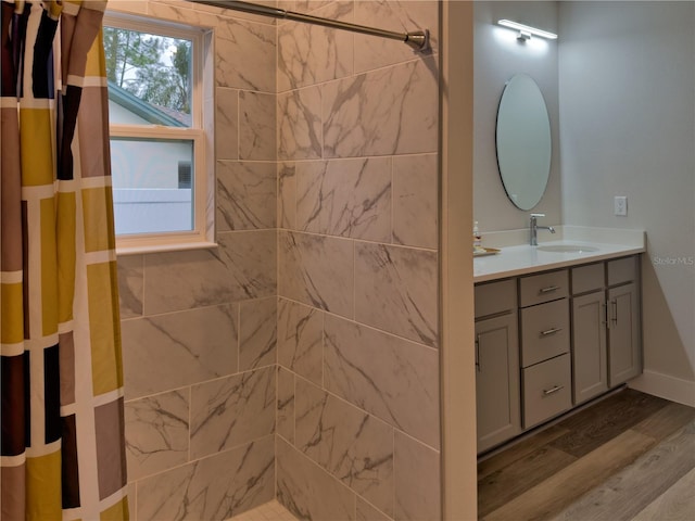 bathroom with walk in shower, vanity, and wood-type flooring