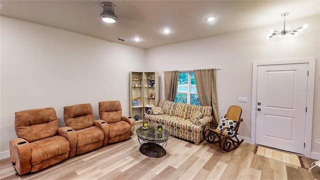 living room featuring light hardwood / wood-style flooring and a notable chandelier