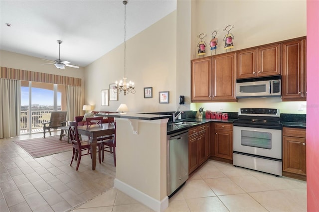 kitchen featuring sink, high vaulted ceiling, kitchen peninsula, stainless steel appliances, and ceiling fan with notable chandelier