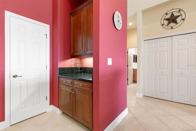 kitchen featuring light tile patterned floors and dark stone counters