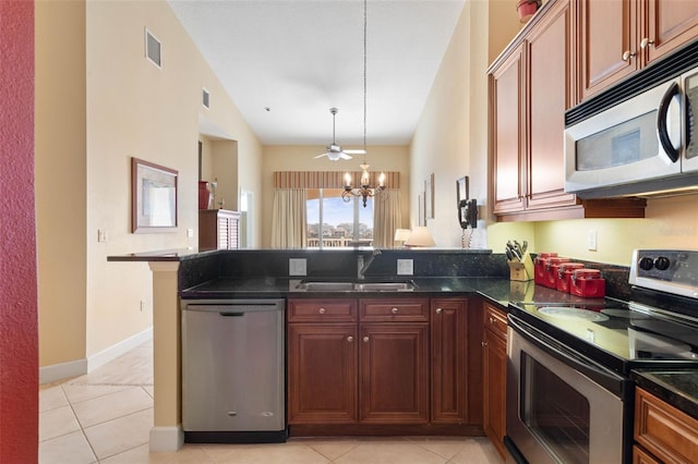 kitchen featuring pendant lighting, sink, appliances with stainless steel finishes, an inviting chandelier, and kitchen peninsula