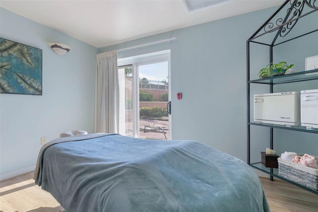 bedroom featuring access to exterior and light hardwood / wood-style flooring