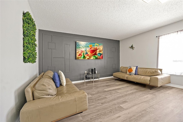 living room featuring a textured ceiling and light hardwood / wood-style flooring