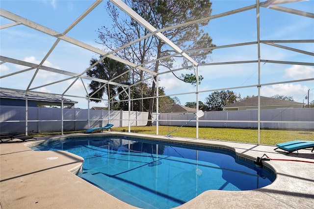 view of swimming pool featuring a patio, glass enclosure, and a yard