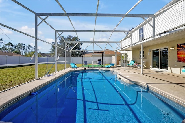 view of pool with a patio, glass enclosure, and a lawn