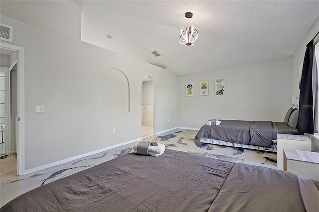 bedroom with a textured ceiling and connected bathroom