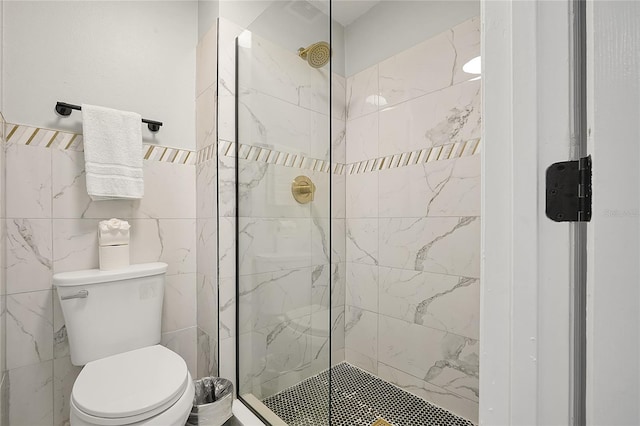 bathroom featuring toilet and a tile shower