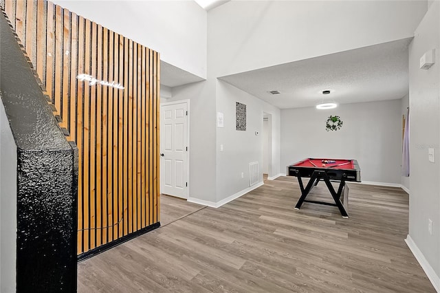 rec room with pool table, hardwood / wood-style floors, and a textured ceiling