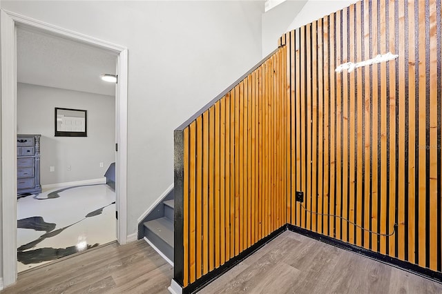 stairs with a textured ceiling and hardwood / wood-style flooring