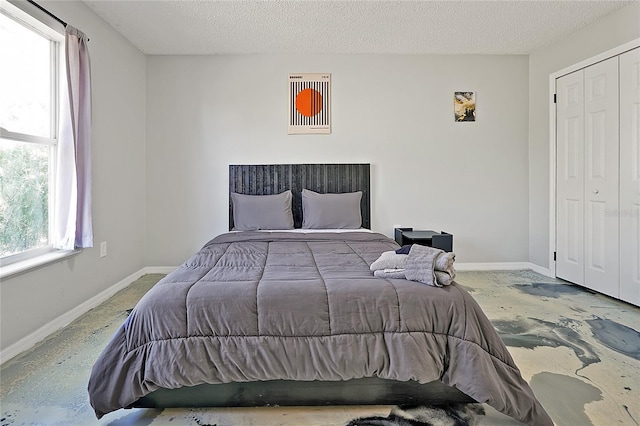 bedroom featuring a textured ceiling and a closet