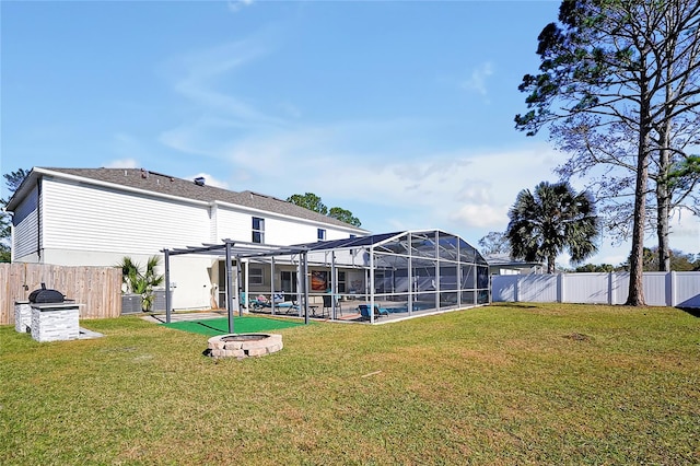 rear view of property featuring a lawn, a fire pit, central AC unit, a pool, and a pergola