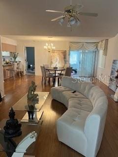 living room with ceiling fan with notable chandelier and hardwood / wood-style flooring