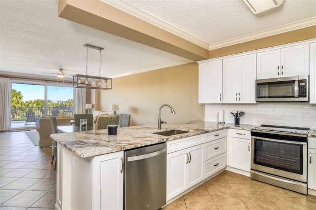 kitchen with stainless steel appliances, kitchen peninsula, a textured ceiling, pendant lighting, and sink