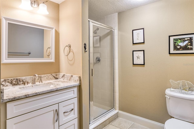 bathroom with toilet, a textured ceiling, tile patterned flooring, a shower with door, and vanity