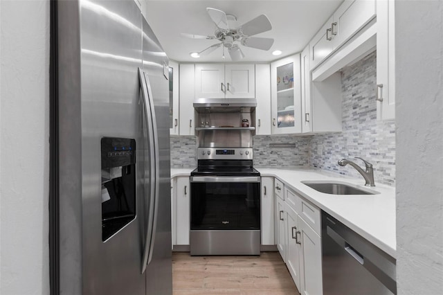 kitchen featuring stainless steel appliances, backsplash, white cabinets, and sink