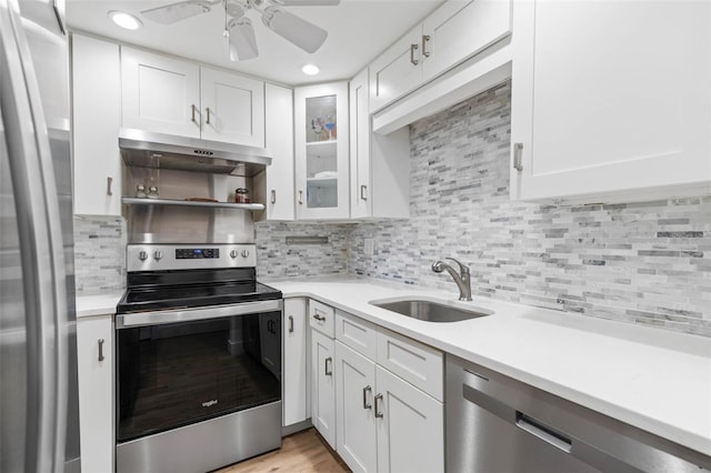 kitchen with sink, white cabinets, appliances with stainless steel finishes, and tasteful backsplash