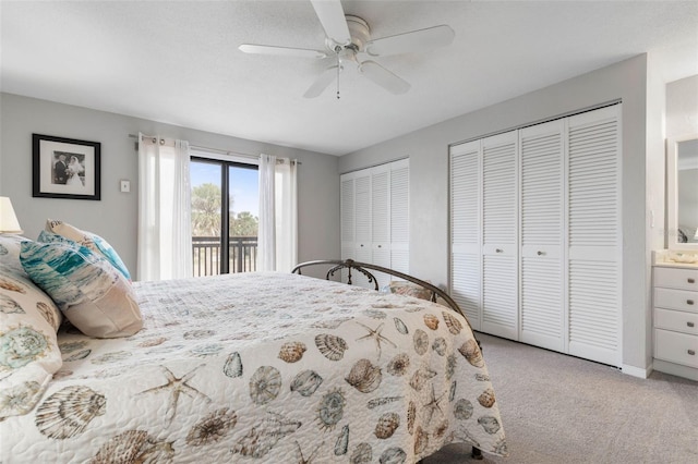 bedroom featuring access to outside, ceiling fan, light carpet, and two closets