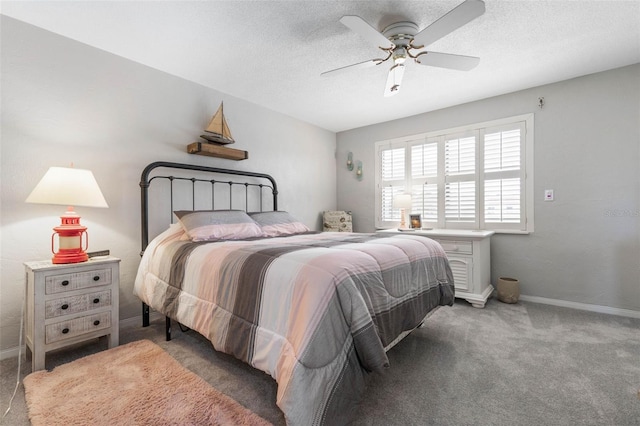 bedroom featuring a ceiling fan, dark colored carpet, a textured ceiling, and baseboards