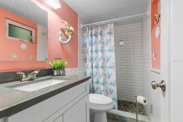 full bath featuring toilet, a wainscoted wall, a shower stall, and vanity