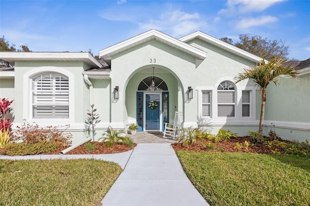 property entrance with a lawn