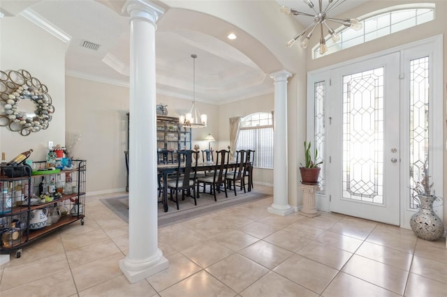 tiled foyer entrance featuring a notable chandelier and crown molding