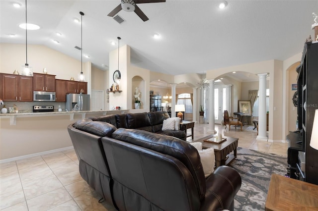 living room with ceiling fan, vaulted ceiling, light tile patterned flooring, and ornate columns