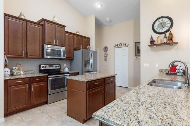 kitchen featuring sink, backsplash, a center island, and stainless steel appliances