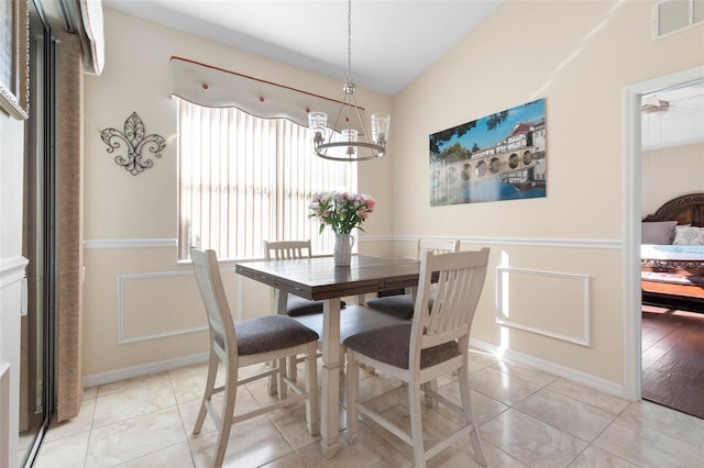 dining space featuring light tile patterned floors and a chandelier