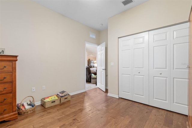 unfurnished bedroom featuring light wood-type flooring and a closet