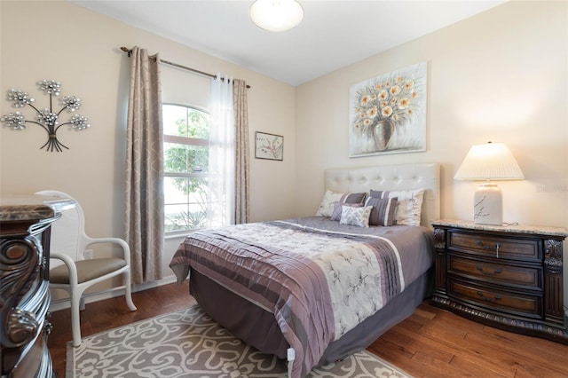 bedroom featuring dark hardwood / wood-style flooring and multiple windows