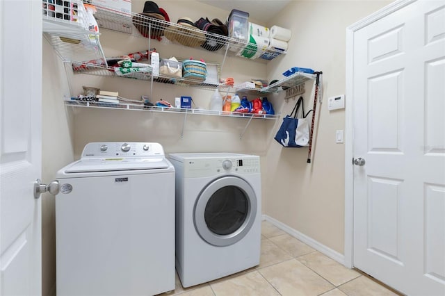 laundry room featuring separate washer and dryer and light tile patterned floors