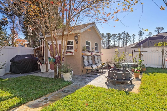 rear view of house featuring an outbuilding, a lawn, and a patio