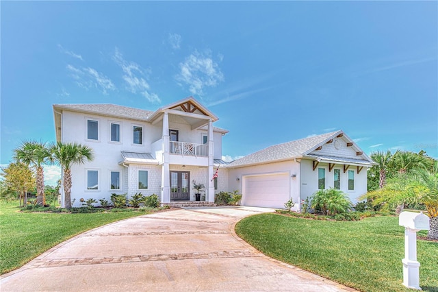 view of front of house with a front yard, a garage, french doors, and a balcony