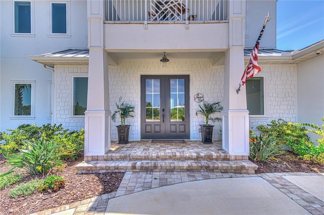 property entrance with a balcony and french doors