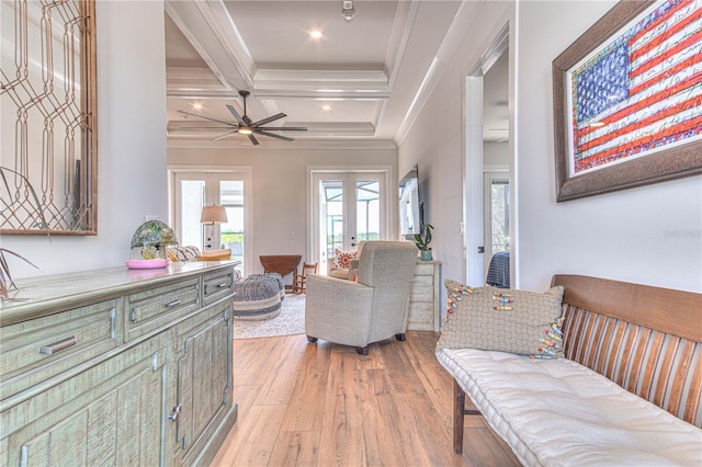 living room with beamed ceiling, ornamental molding, light wood-type flooring, ceiling fan, and coffered ceiling