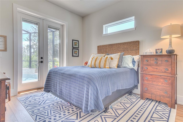 bedroom with access to exterior, multiple windows, french doors, and light wood-type flooring