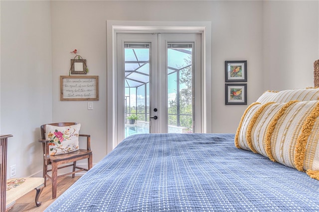 bedroom featuring hardwood / wood-style flooring, french doors, access to outside, and multiple windows