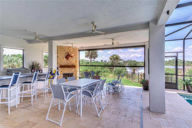 view of patio with ceiling fan, an outdoor bar, and an outdoor stone fireplace