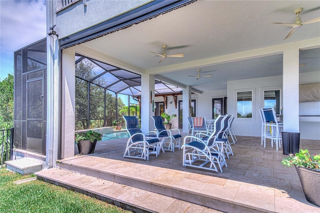 view of patio with ceiling fan and glass enclosure