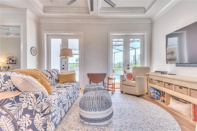 living room with ceiling fan, a wealth of natural light, ornamental molding, and french doors