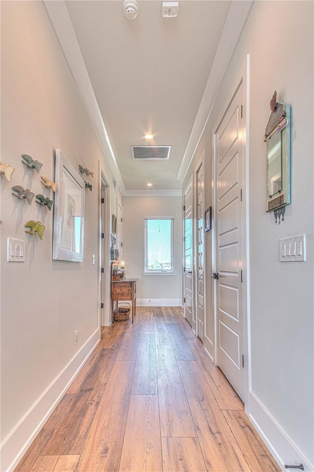 interior space featuring ornamental molding and light hardwood / wood-style flooring