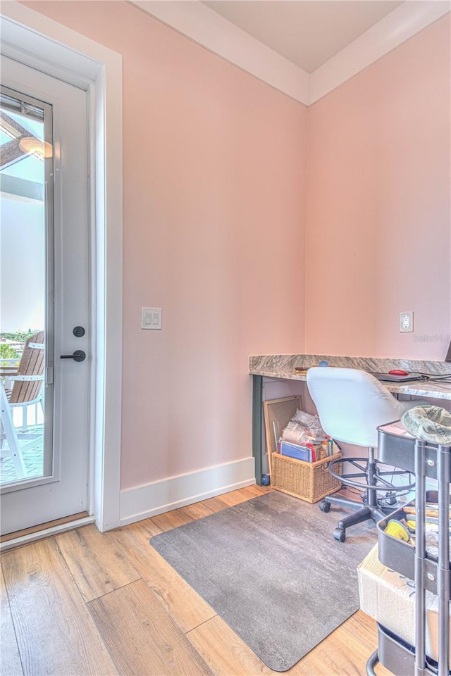 office space with light hardwood / wood-style floors and crown molding