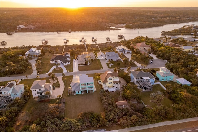 aerial view at dusk featuring a water view