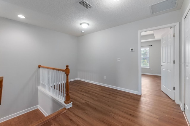 empty room featuring a textured ceiling and hardwood / wood-style flooring