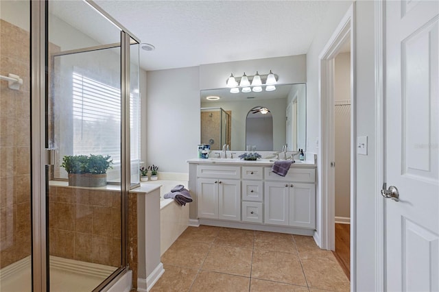 bathroom featuring vanity, tile patterned floors, independent shower and bath, and a textured ceiling