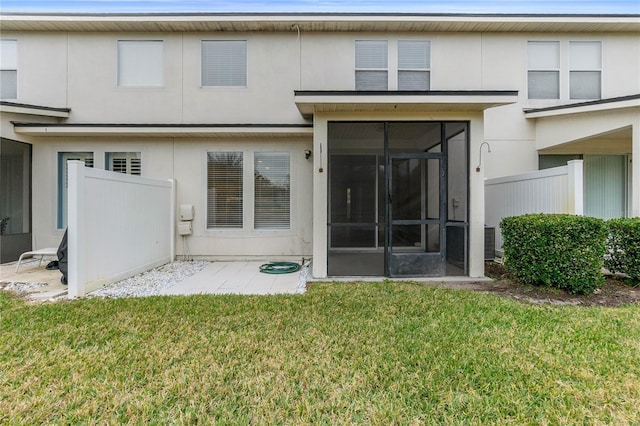 back of property featuring a sunroom and a lawn