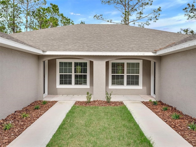 doorway to property with a lawn